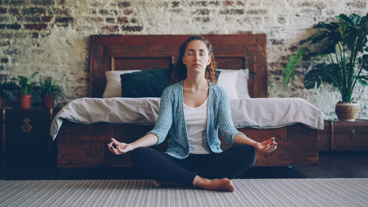 Woman practicing air control method with hand on diaphragm while seated calmly